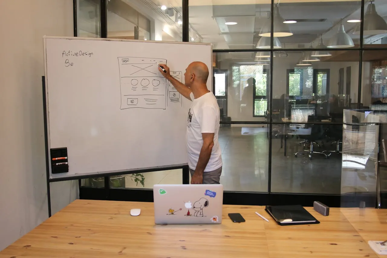 Small business owner mapping AI opportunities on a whiteboard before investing in tools